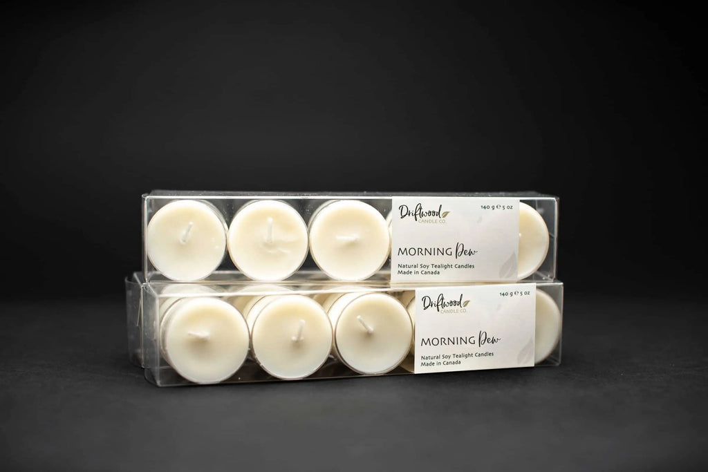 Set of clear tealight boxes filled with ten soy tealights each.  Each box is labelled with the Driftwood Candle co Morning Dew tealight label.